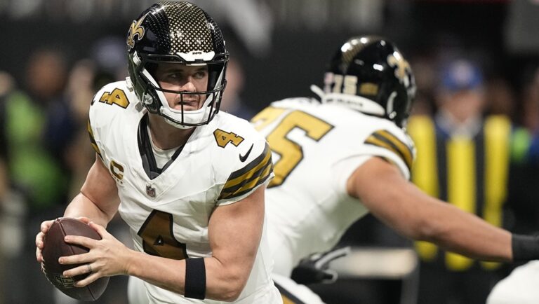 New Orleans Saints quarterback Derek Carr (4) rolls out of the pocket against the Atlanta Falcons during the first half of an NFL football game, Sunday, Nov. 26, 2023, in Atlanta.