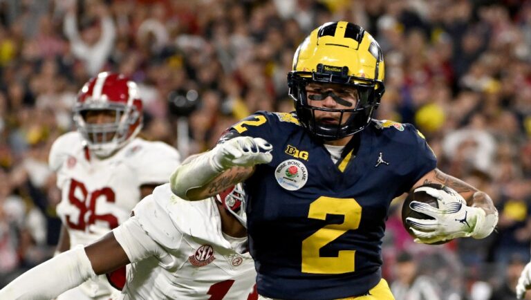 Michigan running back Blake Corum (2) runs in for a touchdown past Alabama defensive back Kool-Aid McKinstry (1) during overtime at the Rose Bowl CFP NCAA semifinal college football game Monday, Jan. 1, 2024, in Pasadena, Calif. (AP Photo/Kyusung Gong)