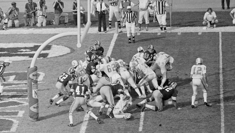 In this Jan. 14, 1973 file photo, Miami Dolphins' Jim Kiick (21) follows teammates Jim Langer (62) and Larry Csonka (39) to score against the Washington Redskins during Super Bowl VII in Los Angeles.