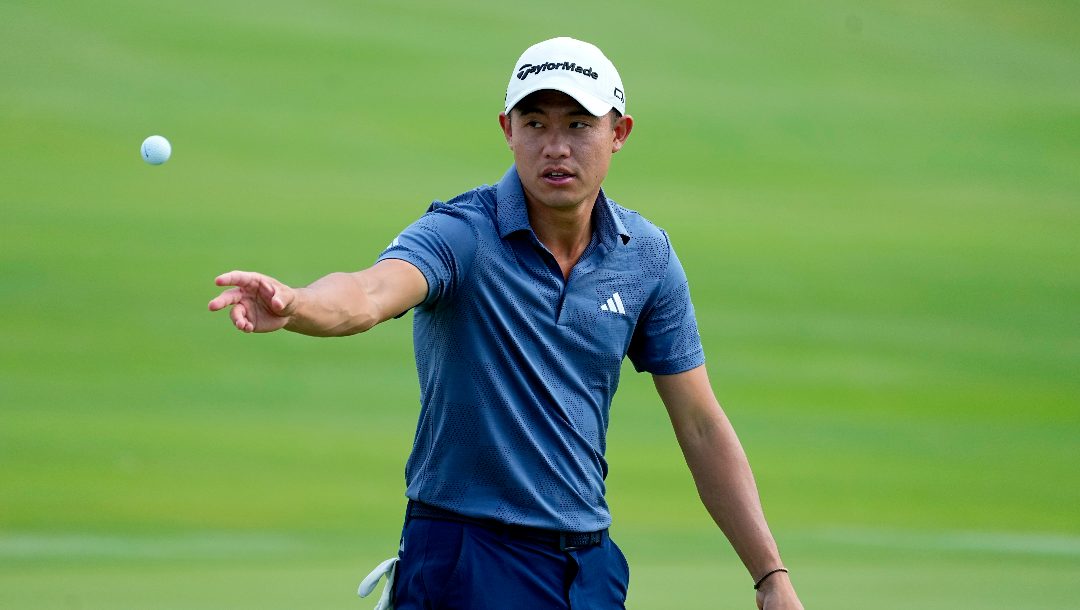 Collin Morikawa tosses his ball to his caddy on the 18th green during the first round of The Sentry golf event, Thursday, Jan. 4, 2024, at Kapalua Plantation Course in Kapalua, Hawaii.
