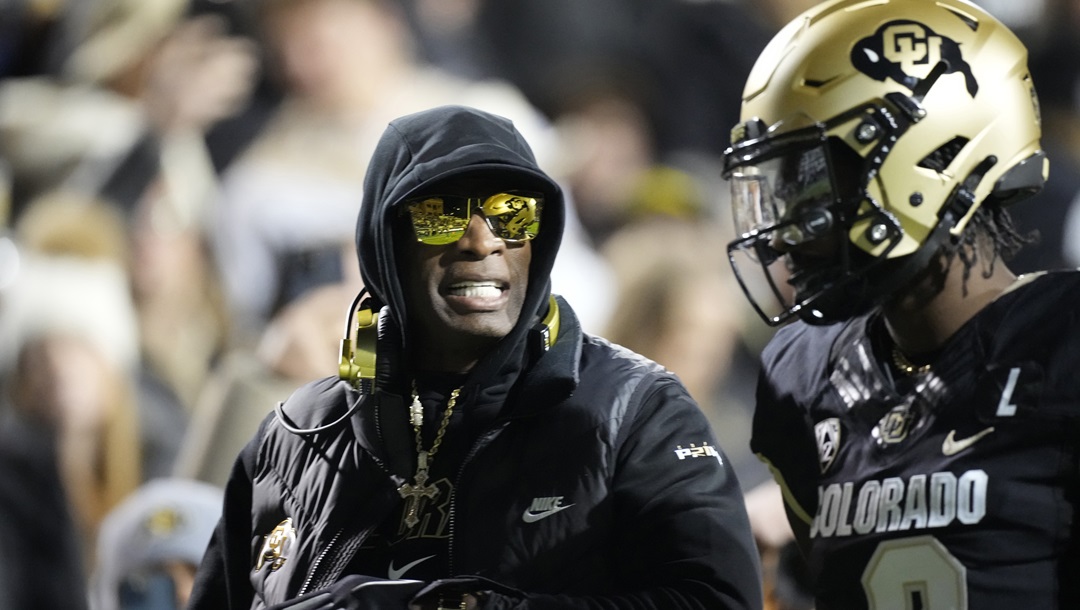 Colorado head coach Deion Sanders, left, talks to his son, quarterback Shedeur Sanders, in the first half of an NCAA college football game against Stanford Friday, Oct. 13, 2023, in Boulder, Colo. Deion Sanders is accomplishing what he pledged to do by overhauling his offensive line to better protect his often-hit quarterback son. The Colorado coach reached into the transfer portal and brought in linemen from the University of Houston, Connecticut, Indiana and UTEP.