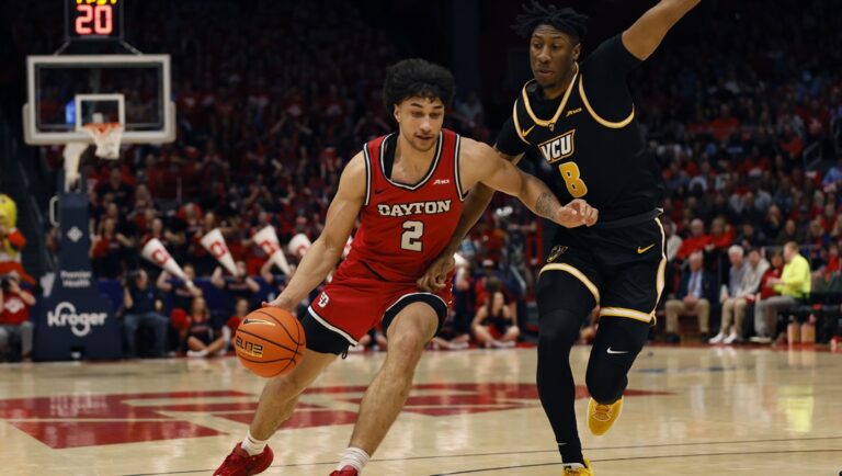 Dayton's Nate Santos, left, drives to the basket against Virginia Commonwealth's Michael Belle, right, during the second half of an NCAA college basketball game Friday, March 8, 2024, in Dayton, Ohio.