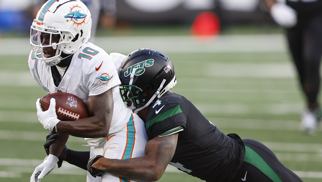New York Jets cornerback D.J. Reed (4) tackles Miami Dolphins wide receiver Tyreek Hill (10) during the first quarter of an NFL football game, Friday, Nov. 24, 2023, in East Rutherford, N.J.