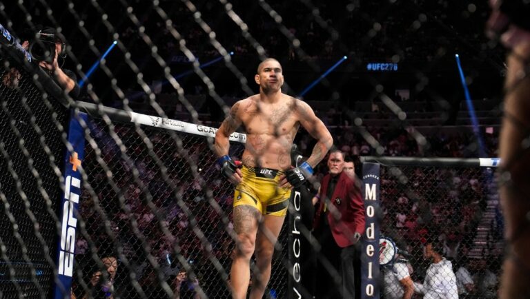 Alex Pereira, center, reacts after winning a middleweight bout against Sean Strickland during the UFC 276 mixed martial arts event.