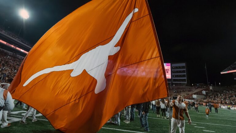 A Texas cheerleader waves a Texas Longhorn flag after an NCAA college football game against Texas Tech, Friday, Nov. 24, 2023, in Austin, Texas. Texas won 57-7.