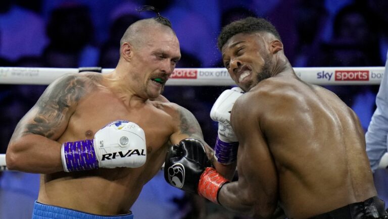 Britain's Anthony Joshua, right, takes a blow from Ukraine's Oleksandr Usyk during their world heavyweight title fight.
