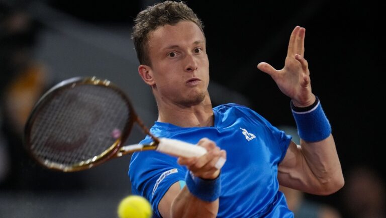 Jiri Lehecka, of Czech Republic, returns a ball to Rafael Nadal of Spain, during the Mutua Madrid Open tennis tournament in Madrid, Tuesday, April 30, 2024.
