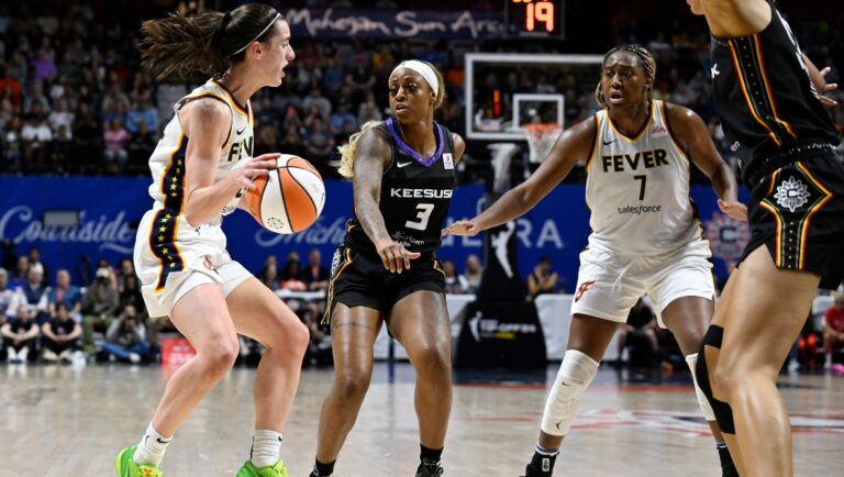 Indiana Fever guard Caitlin Clark looks to pass to Indiana Fever forward Aliyah Boston (7) as Connecticut Sun forward Tiffany Mitchell (3) defends in the second half of a WNBA basketball game, Tuesday, May 14, 2024, in Uncasville, Conn.