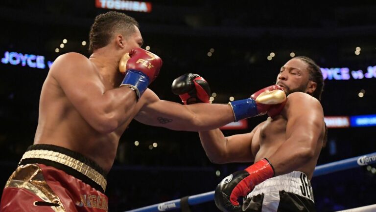 Joe Joyce, left, of England, connects with a left to Joe Hanks during a WBA continental heavyweight boxing bout Saturday.