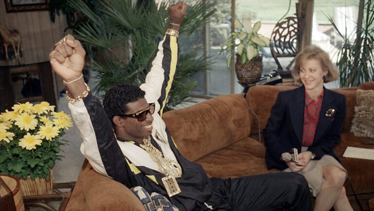 Florida State's Deion Sanders, left, reacts as he sits with television reporter Andrea Kremer, at his agent's suburban home in Winnetka, Ill., on April 23, 1989. Sanders was selected by the Atlanta Falcons in the first round of the NFL draft. Sanders, a two-time All-American cornerback at FSU, was the fifth player selected in the first round.