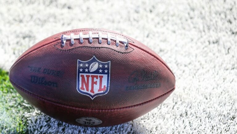A football with the NFL logo sits on the field before an NFL football game between the Tennessee Titans and the Baltimore Ravens, Sunday, Oct. 15, 2023, in London. (AP/Gary McCullough)