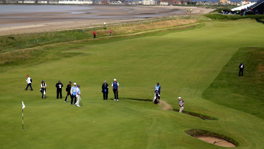 Brandt Snedeker of the US, right, plays out of a sand trap on the 1st green during a practice round for the British Open Golf Championships at the Royal Troon Golf Club in Troon, Scotland, Tuesday, July 12, 2016.
