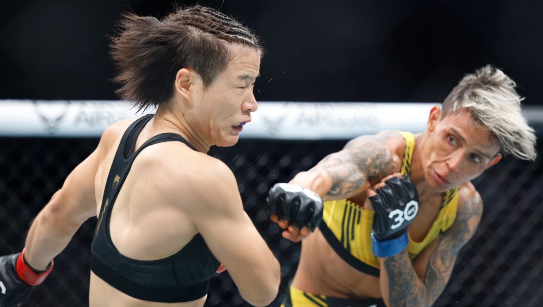 Zhang Weili absorbs a right hand from Amanda Lemos during their UFC 292 Strawweight title mixed martial arts fight.
