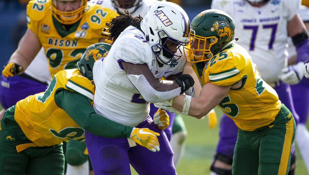 James Madison running back Latrele Palmer (21) is tackled by North Dakota State safety Michael Tutsie (25) and defensive end Tony Pierce (90) during the second half of the FCS championship NCAA college football game, Saturday, Jan. 11, 2020, in Frisco, Texas.