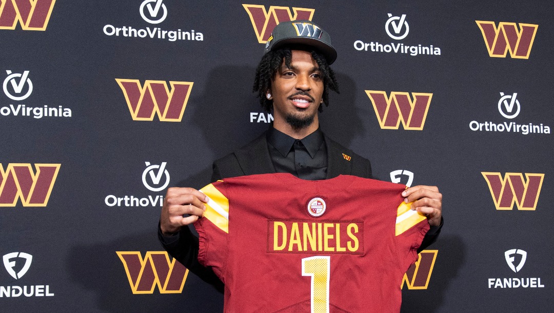 Washington Commanders' first round draft pick Jayden Daniels holds his Commanders jersey during an NFL football news conference in Ashburn, Va., Friday, April 26, 2024. (AP Photo/Manuel Balce Ceneta)