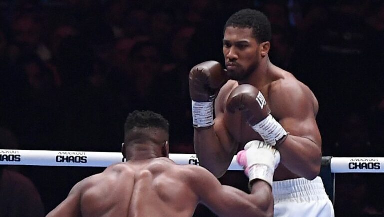 British former world champion Anthony Joshua, right, and MMA fighter Francis Ngannou fight during the heavyweight boxing showdown.