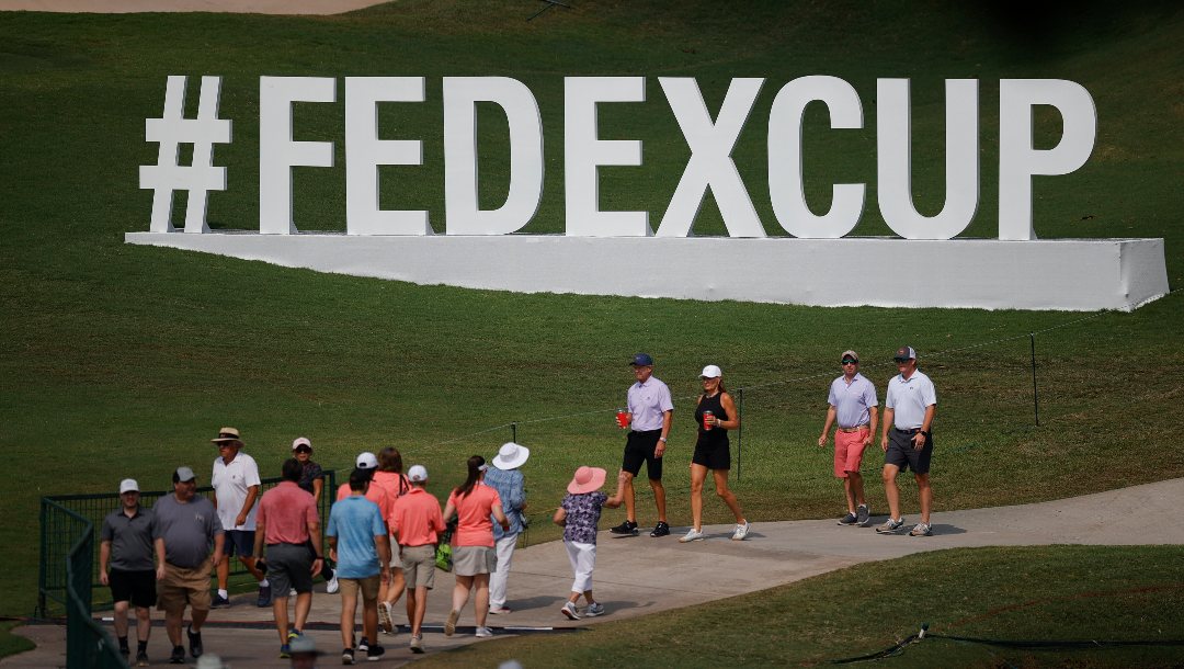 Spectators walk past cup signage during the first round of the Tour Championship golf tournament at East Lake Golf Club, Thursday, Aug. 24, 2023, in Atlanta.