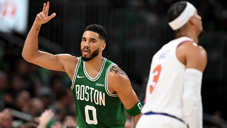 Jayson Tatum #0 of the Boston Celtics reacts after a three pointer as Josh Hart #3 of the New York Knicks looks on during the first half at TD Garden on October 22, 2024 in Boston, Massachusetts.