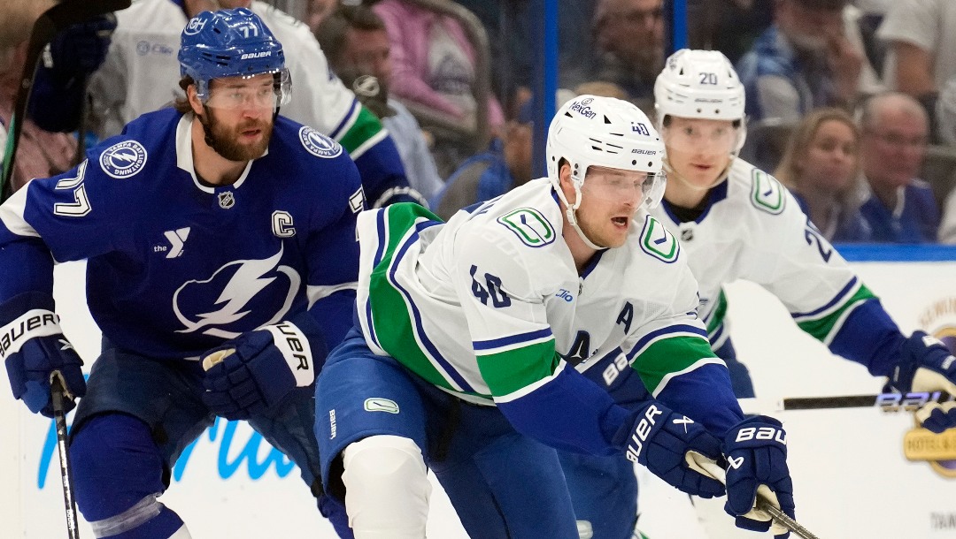 Vancouver Canucks center Elias Pettersson (40) moves the puck around Tampa Bay Lightning defenseman Victor Hedman (77) during the first period of an NHL hockey game Tuesday, Oct. 15, 2024, in Tampa, Fla. (AP Photo/Chris O'Meara)