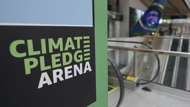 A sign inside Climate Pledge Arena is shown Wednesday, Oct. 20, 2021, during a media tour ahead of the NHL hockey Seattle Kraken's home opener Saturday against the Vancouver Canucks in Seattle. The historic angled roof of the former KeyArena was preserved, but everything else inside the venue, which will also host concerts and be the home of the WNBA Seattle Storm basketball team, is brand new.