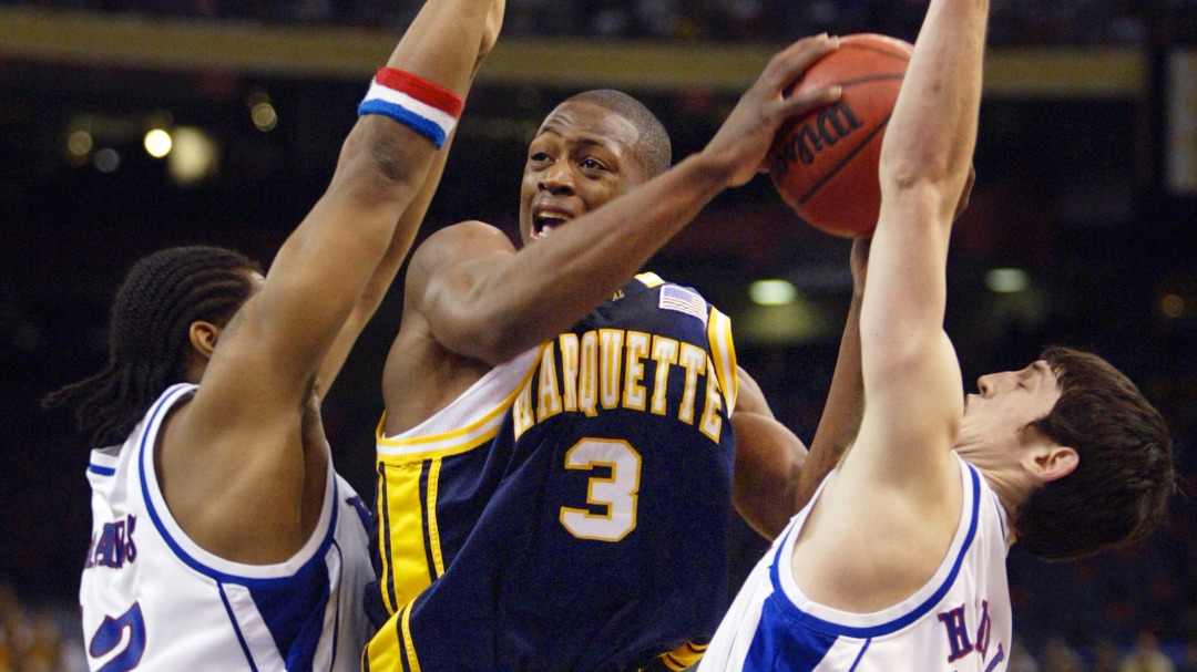 Marquette's Dwyane Wade (3) tries to drive between Kansas defenders Jeff Graves, left, and Kirk Hinrich in the first half of their semifinal game at the Final Four on Saturday, April 5, 2003, in New Orleans.