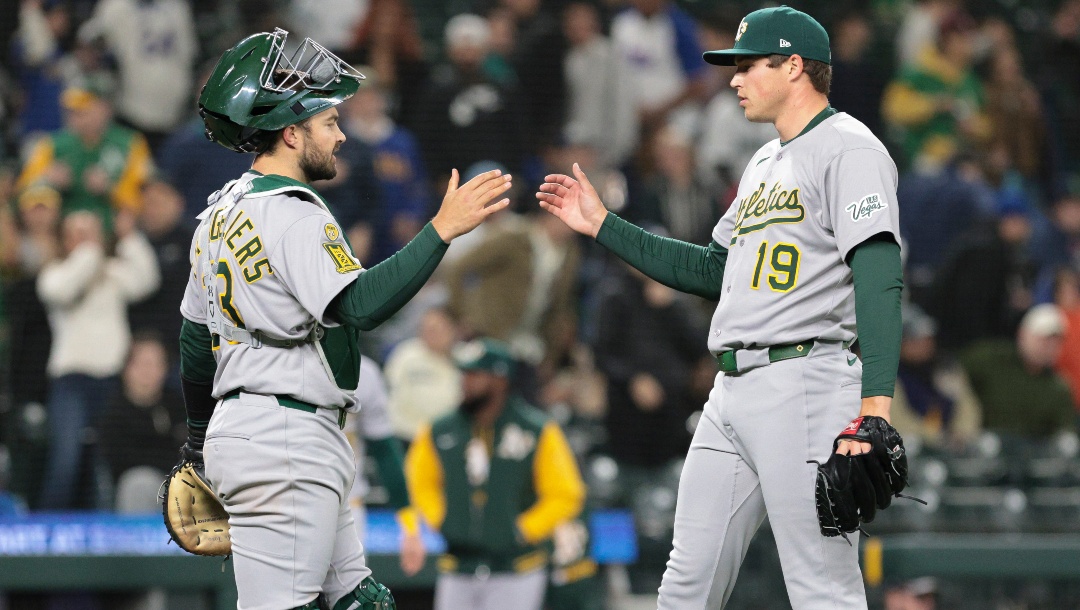 Athletics catcher Shea Langeliers, left, celebrates with closing pitcher Mason Miller after defeating the Seattle Mariners in a baseball game, Saturday, March 29, 2025, in Seattle.