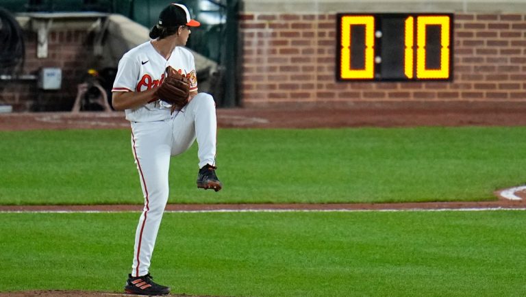 The pitch clock is visible as Baltimore Orioles starting pitcher Dean Kremer winds up to deliver during the sixth inning of a baseball game against the Boston Red Sox, April 24, 2023, in Baltimore, Md.