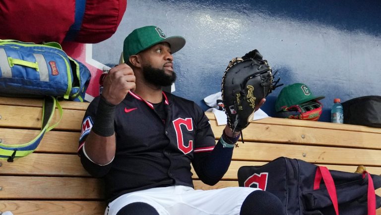 Cleveland Guardians' Carlos Santana pauses in the dugout prior to a spring training baseball game against the Cincinnati Reds, Monday, March 17, 2025, in Goodyear, Ariz. (AP Photo/Ross D. Franklin)