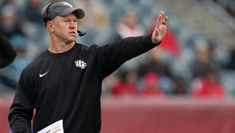 In this Saturday, Nov. 18, 2017, file photo, Central Florida head coach Scott Frost signals to his team during the third quarter of an NCAA college football game against Temple in Philadelphia. Frost and nine of his assistants will be full-time Nebraska employees immediately after the Peach Bowl game against Auburn on Monday, Jan. 1, 2018. Until then, they’ve worked almost nonstop to make sure the Central Florida players feel no disruption in their normal practice-day schedules.
