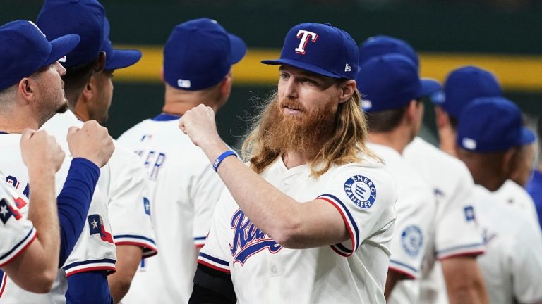 Texas Rangers pitcher Jon Gray, right wearing a cast on his right arm, is greeted by the team during introductions before an opening-day baseball game against the Boston Red Sox, Thursday, March 27, 2025, in Arlington, Texas. (AP Photo/Tony Gutierrez)