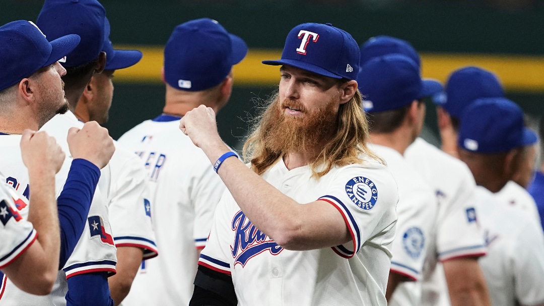 Texas Rangers pitcher Jon Gray, right wearing a cast on his right arm, is greeted by the team during introductions before an opening-day baseball game against the Boston Red Sox, Thursday, March 27, 2025, in Arlington, Texas. (AP Photo/Tony Gutierrez)