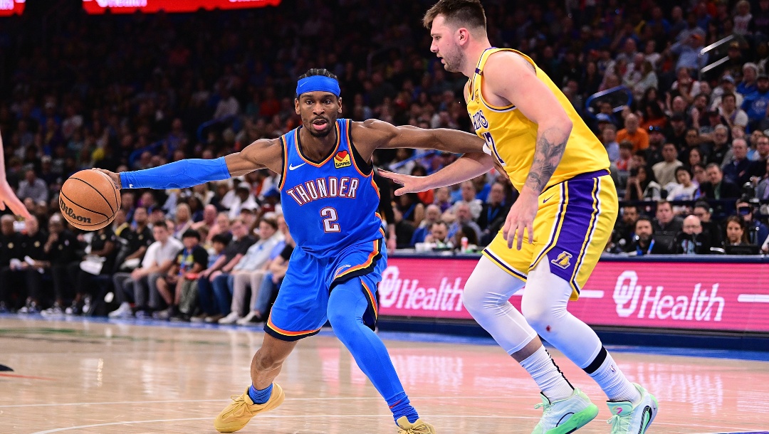 Shai Gilgeous-Alexander #2 of the Oklahoma City Thunder handles the ball in front of Luka Doncic #77 of the Los Angeles Lakers during the first half at Paycom Center on April 8, 2025 in Oklahoma City, Oklahoma.