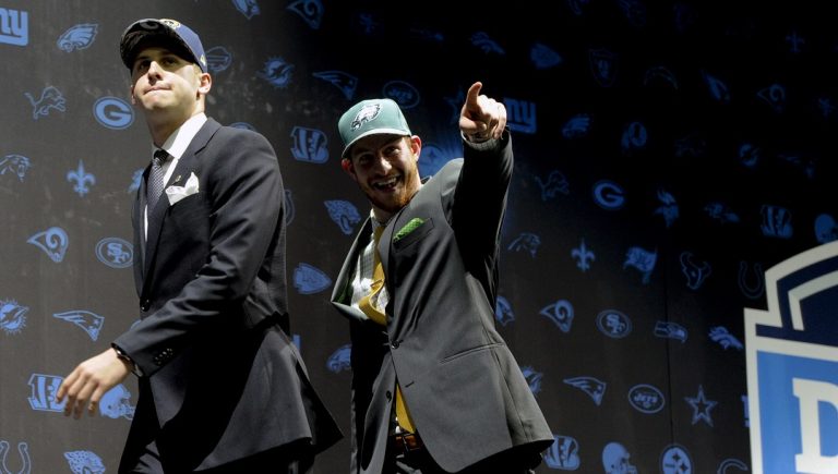 In this April 28, 2016, file photo, Jared Goff, left, after being selected by Los Angeles Rams as their number one overall pick and Carson Wentz, after being selected by the Philadelphia Eagles as their top pick in the first round of the 2016 NFL football draft, greet fans at Selection Square in Grant Park, in Chicago. Your assignment, as No. 1 overall pick in April's draft who has not gotten on the field yet, but starts Sunday for the Rams against the Dolphins, is simple: win. Just go out and play like fellow rookie quarterbacks Dak Prescott in Dallas and Carson Wentz in Philadelphia have done.
