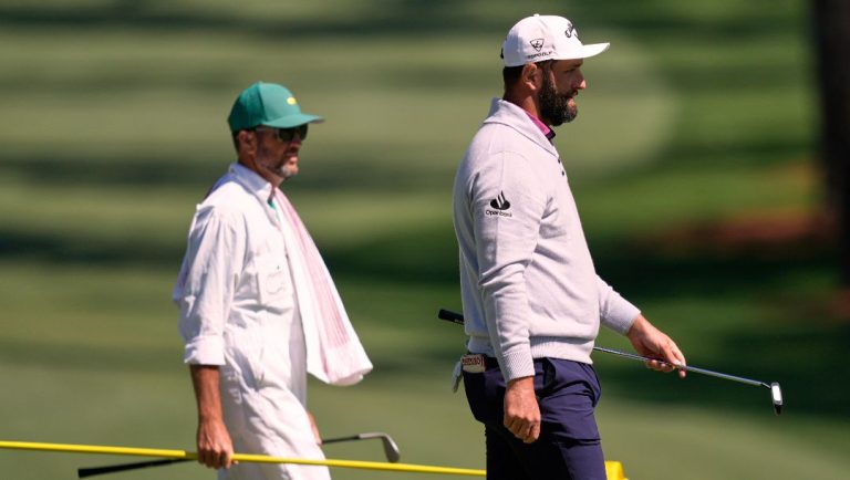 Jon Rahm, of Spain, right, and his caddie Adam Hayes, walk off the 10th green during a practice round at the Masters golf tournament, Tuesday, April 8, 2025, in Augusta, Ga.