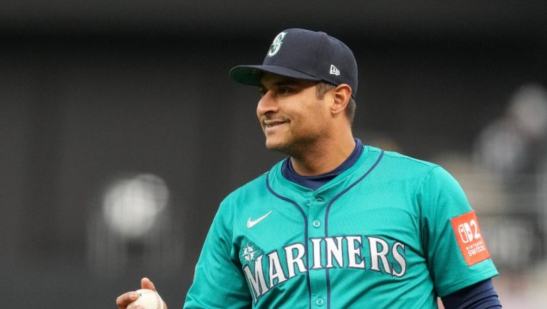 Seattle Mariners first baseman Donovan Solano reacts to a single by Cincinnati Reds second base Gavin Lux (2) during a baseball game, Tuesday, April 15, 2025, in Cincinnati. All the players are wearing 42 in honor of Jackie Robinson Day. (AP Photo/Jeff Dean)