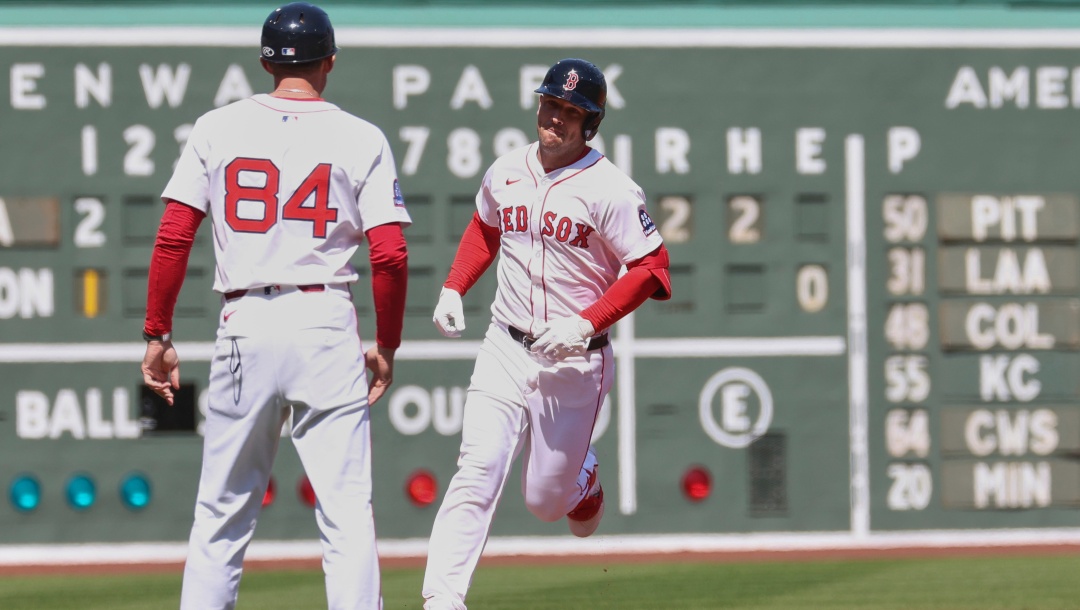 Boston Red Sox's Alex Bregman, right, runs past third base coach Kyle Hudson (84) after hitting a home run during the first inning of a baseball game against the Seattle Mariners, Thursday, April 24, 2025, in Boston.