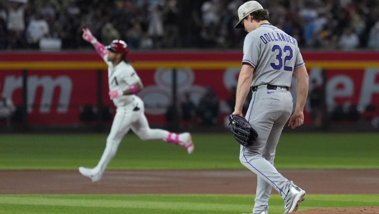 Colorado Rockies starting pitcher Chase Dollander (32) walks off the pitcher's mound after giving up a home run to Arizona Diamondbacks' Ketel Marte, left, during the first inning of a baseball game Sunday, May 18, 2025, in Phoenix.