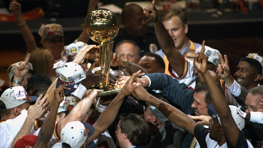 Basketball: NBA Finals: Houston Rockets team victorious, with Larry O'Brien trophy and NBC Sports announcer Bob Costas after winning Game 4 and championship series vs Orlando Magic at The Summit. Houston, TX 6/14/1995