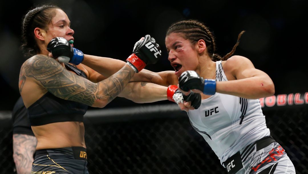Julianna Pena, right, hits Amanda Nunes during a women's bantamweight mixed martial arts title bout at UFC 269, Saturday.