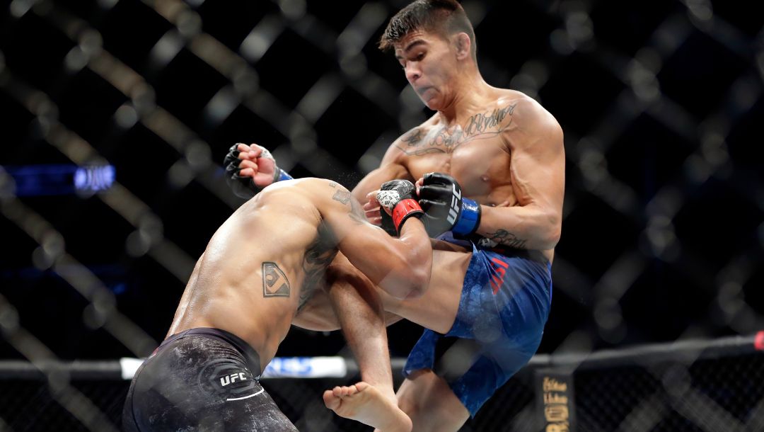 Miles Johns, left, takes a knee to the head from Mario Bautista, right, dropping Johns to the canvas during the second round.
