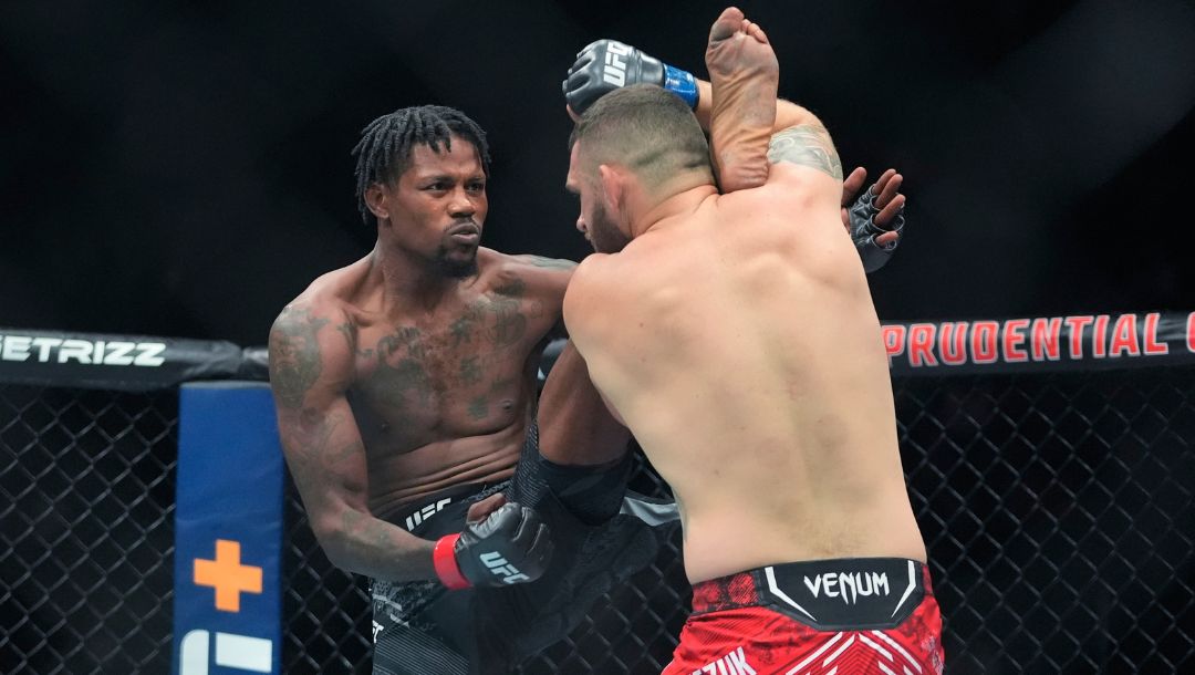 Poland's Michal Oleksiejczuk grabs the leg of Kevin Holland during the first round of a middleweight bout at the UFC 302.