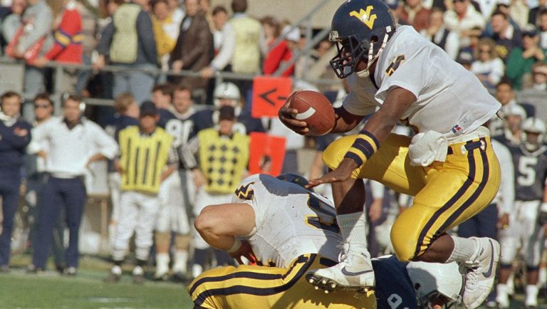 Major Harris, West Virginia quarterback, leaps over Penn State defender Aoatoa Polamalu (99) gaining a 1st down on a play option run in 1st period of game at State College, Pa. on Saturday, Oct. 31, 1987.
