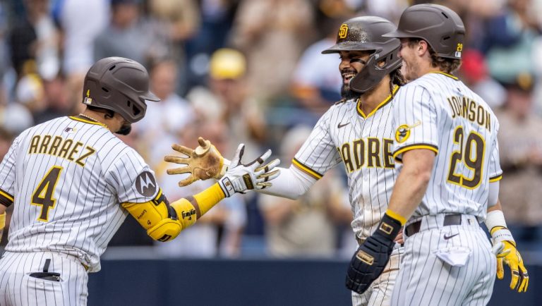 San Diego Padres' Luis Arraez (4) and Bryce Johnson (29) celebrate a home run by Fernando Tatis Jr., center, in the seventh inning of a baseball game against the Kansas City Royals, Saturday, June 21, 2025, in San Diego.