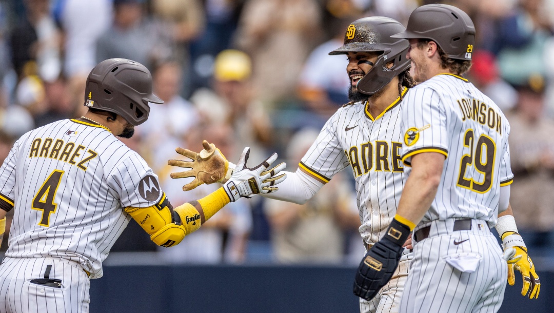 San Diego Padres' Luis Arraez (4) and Bryce Johnson (29) celebrate a home run by Fernando Tatis Jr., center, in the seventh inning of a baseball game against the Kansas City Royals, Saturday, June 21, 2025, in San Diego.