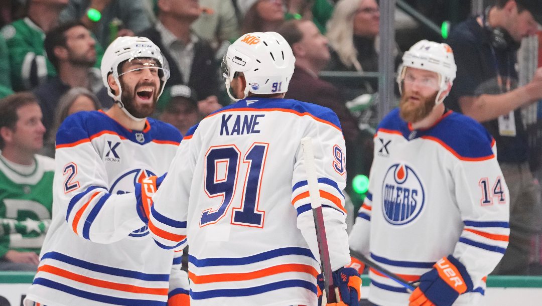 Edmonton Oilers left wing Evander Kane (91) celebrates with defenseman Evan Bouchard (2) and defenseman Mattias Ekholm (14) after scoring against the Dallas Stars during the third period of Game 5 of the Western Conference finals in the NHL hockey Stanley Cup playoffs, Thursday, May 29, 2025, in Dallas.