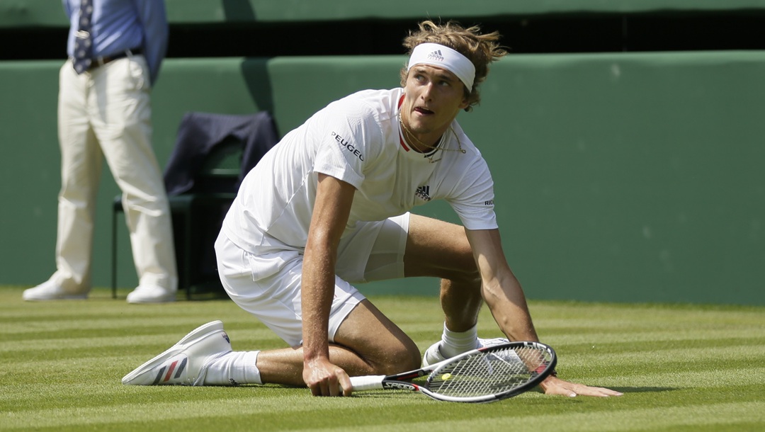 Alexander Zverev of Germany slips on the grass during the men's singles match against Taylor Fritz of the US on the fifth day at the Wimbledon Tennis Championships in London, Friday July 6, 2018.