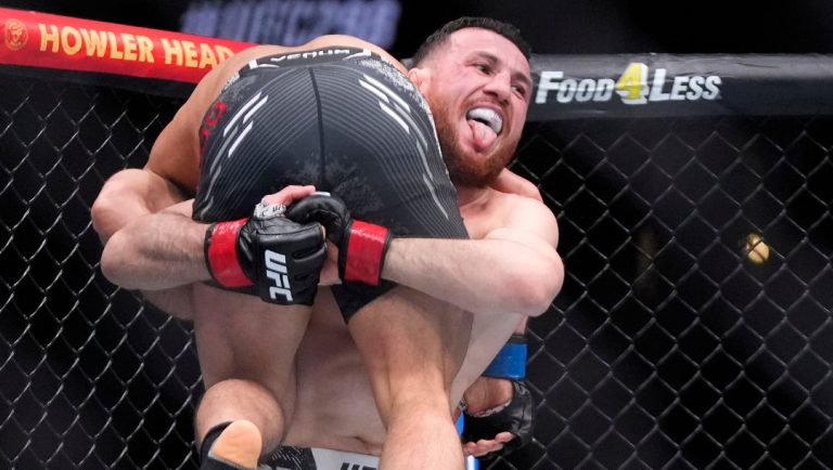 Merab Dvalishvili, right, picks up Henry Cejudo during their bantamweight bout at the UFC 298 mixed martial arts event.