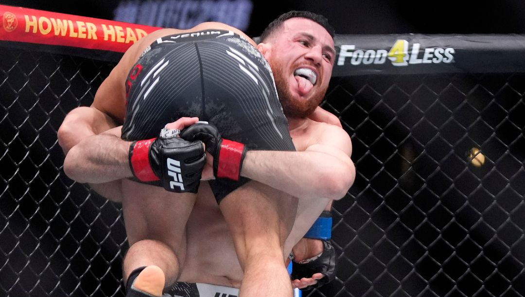 Merab Dvalishvili, right, picks up Henry Cejudo during their bantamweight bout at the UFC 298 mixed martial arts event.