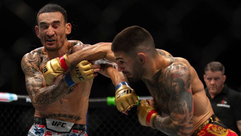 Champion Ilia Topuria, left, punches Max Holloway during a mixed martial arts featherweight title bout at UFC Fight Night.
