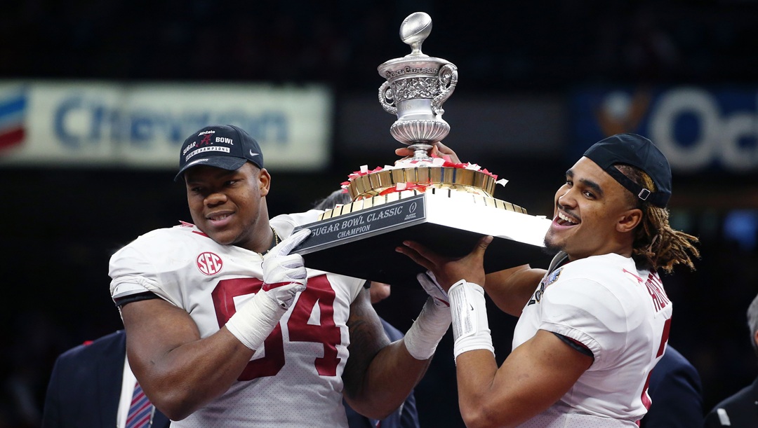 Alabama quarterback Jalen Hurts (2) and defensive lineman Da'Ron Payne (94) hoist the bowl trophy after defeating Clemson in the Sugar Bowl semi-final playoff game for the NCAA college football national championship, in New Orleans, Monday, Jan. 1, 2018. Alabama won 24-6 to advance to the national championship game.